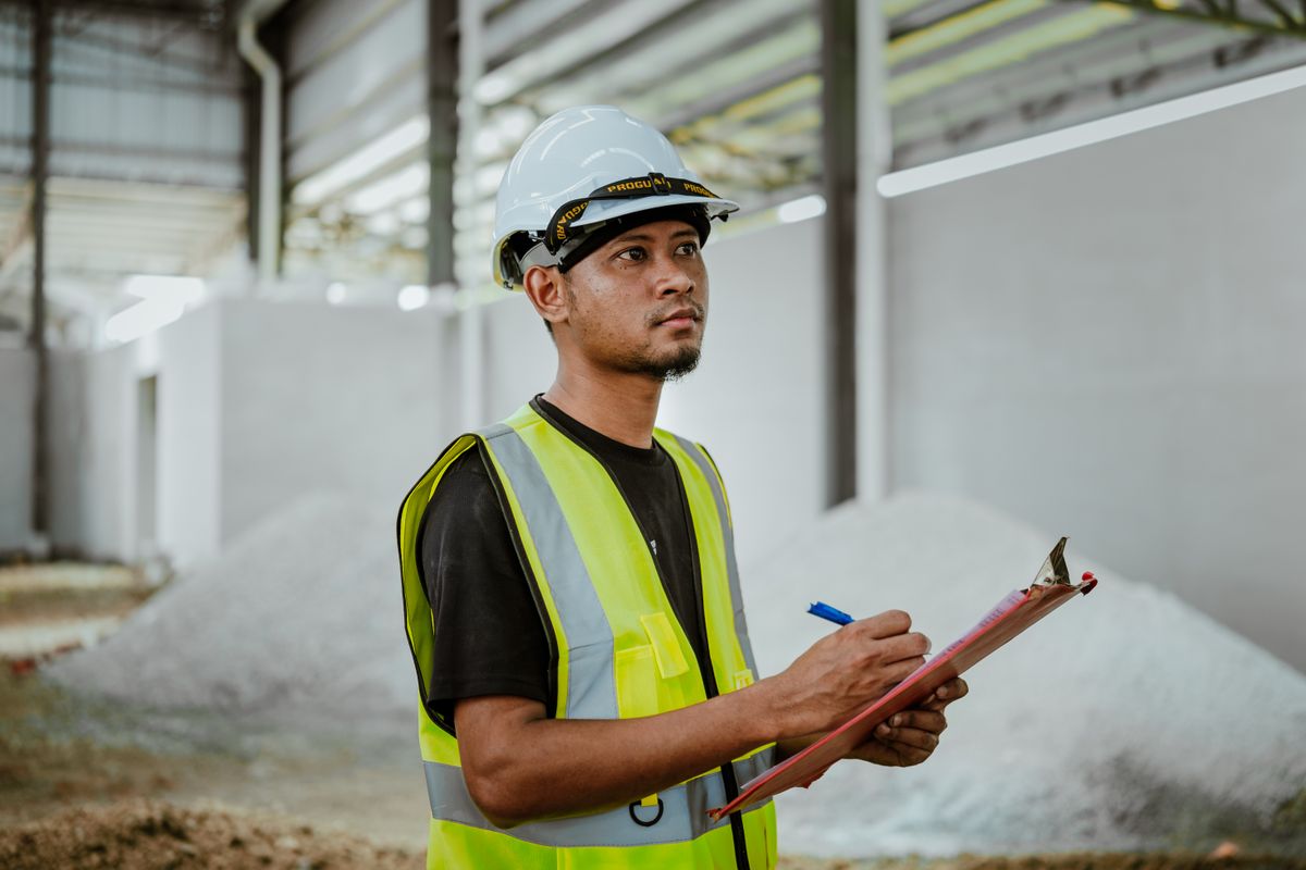 Engineer performing a maintenance inspection with a clipboard on the factory floor